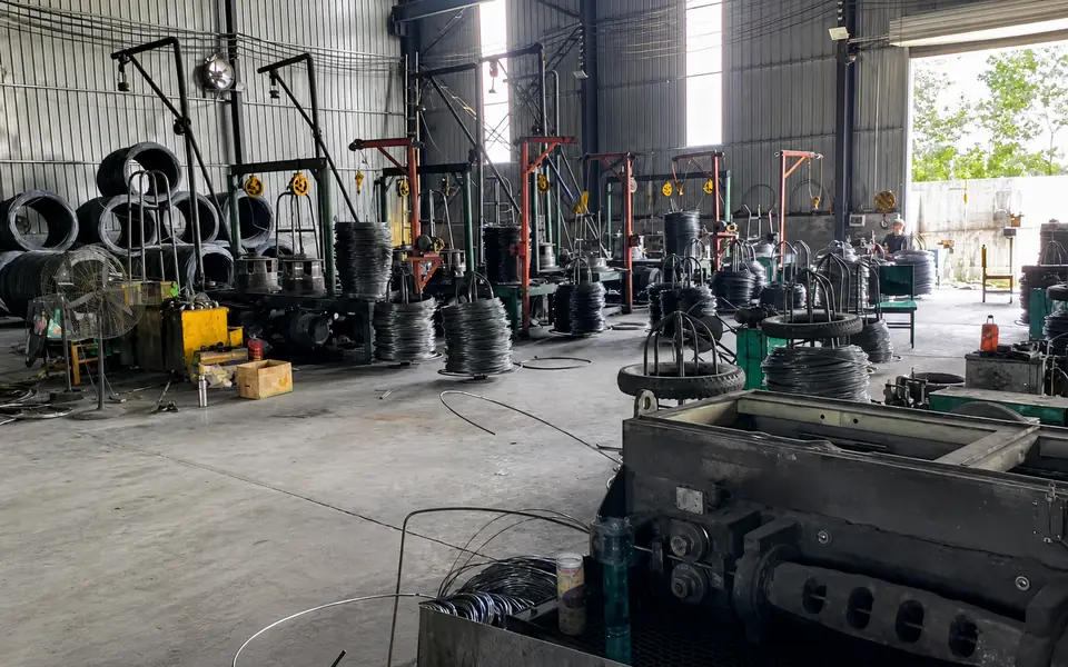 Multiple wire-processing stations, coils and payoff frames inside the Xianhong Mining workshop
